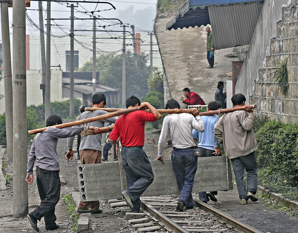 Lifting Gang
Materials for building work up the hill are manhandled across the line. Yue Jin, Shibanxi Line, China. 
