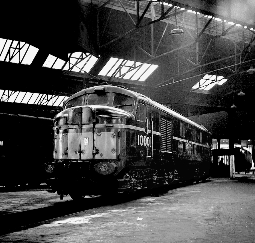 Sleeping in the shadows.
As it is now 60 years since I took up railway photography I thought that I would put in one of my earliest modern traction (!) shots. It shows English-Electric 10001 stabled inside the roundhouse at Willesden shed.
The shot was taken with my first camera - a Lubitel 2 plastic-bodied twin-lens reflex design imported from the USSR in large quantities in the early 1960's and sold for the bargain price of £5 in old money! However, the simple 3-element lens lacked edge sharpness at large apertures, as seen here
