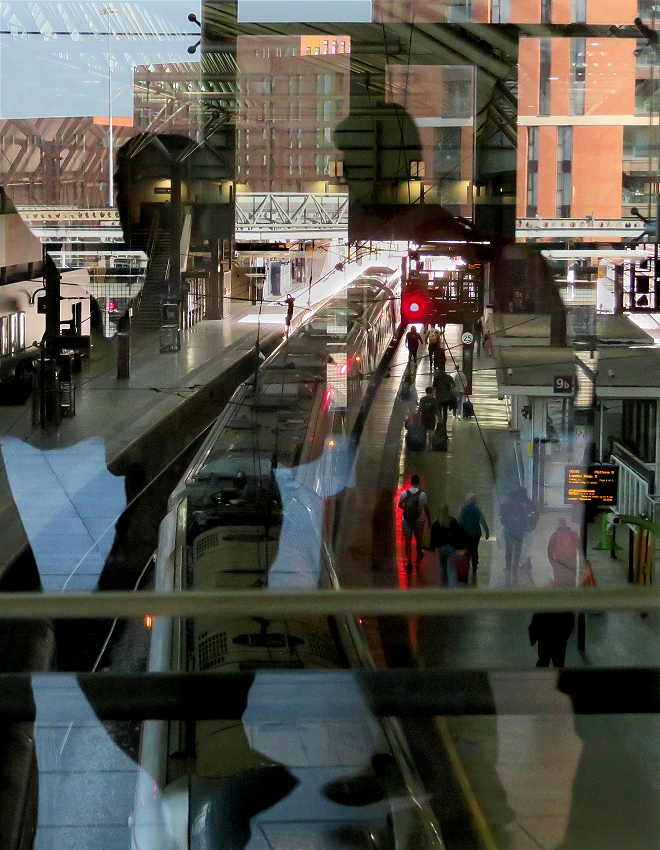 Reflect on these reflections.
This is an alternative portrait composition of the shot I entered in print box E.
It was taken from the upper level at Leeds station looking down on the platfroms through a glass screen - the shadowy figues were actually passing behind me, and the buildings at the top are reflections of the view from the windows behind me at the other side of this level.
The various reflections seem to have interacted in the camera with the foreground view to produce these odd effects.
