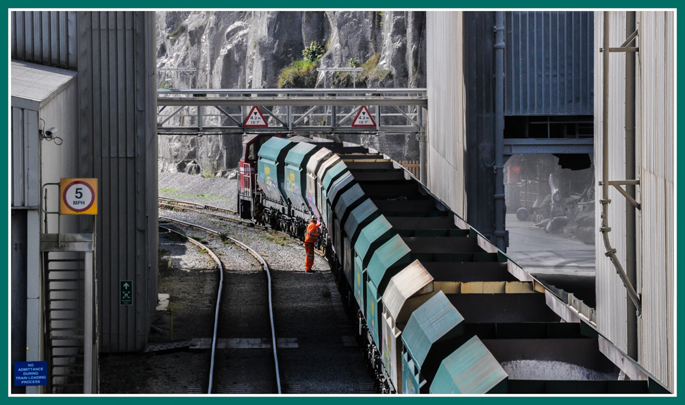 The Wagon Checker
Down in the depths of Tunstead Quarry, the shunter checks the wagons before heading off to the stone batch loader. A Hunslet shunter sits at the head of the consist.


