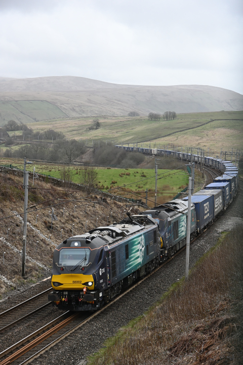 Curving through the Fells
Class 88 88002 Prometheus pilots class 68 68033 The Poppy as the duo climb past Greenholme whilst ascending Shap with the Daventry - Coatbridge TescoLiner service.

