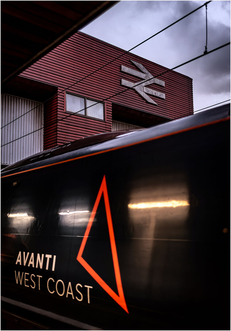 Logo Logic
The rear of 390118 departs Birmingham International with the Avanti three points logo prominent under the watchful eye of a classic (in logo terms) the B.R. Double Arrow designed by Gerry Barney and introduced in 1965; 9S80 the 15:20 Rugby to Wigan North Western was the route for 118 on this occasion. 
