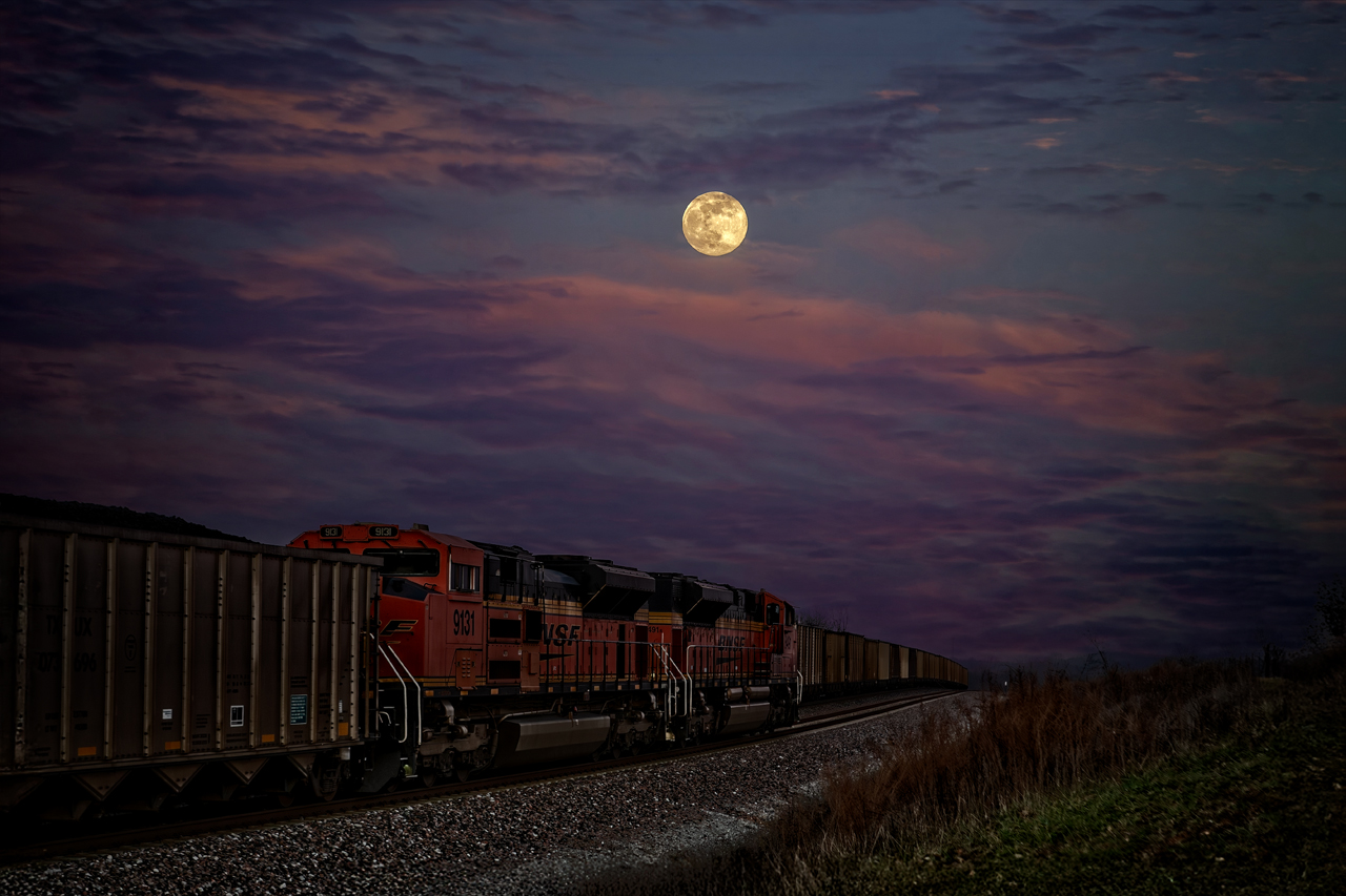 Passing in the night under the Wolf Moon
A southbound loaded coal train passes its empty counterpart at Turners, Missouri, under the full moon.  Both trains are part of the longest single-road coal haul in the US, traveling 3,000 miles round trip from the Powder River Basin in Wyoming to near Birmingham, AL.  With the power plant burning about 2.5 135-car sets of coal a day, it takes 24 sets of coal cars to keep it running.
