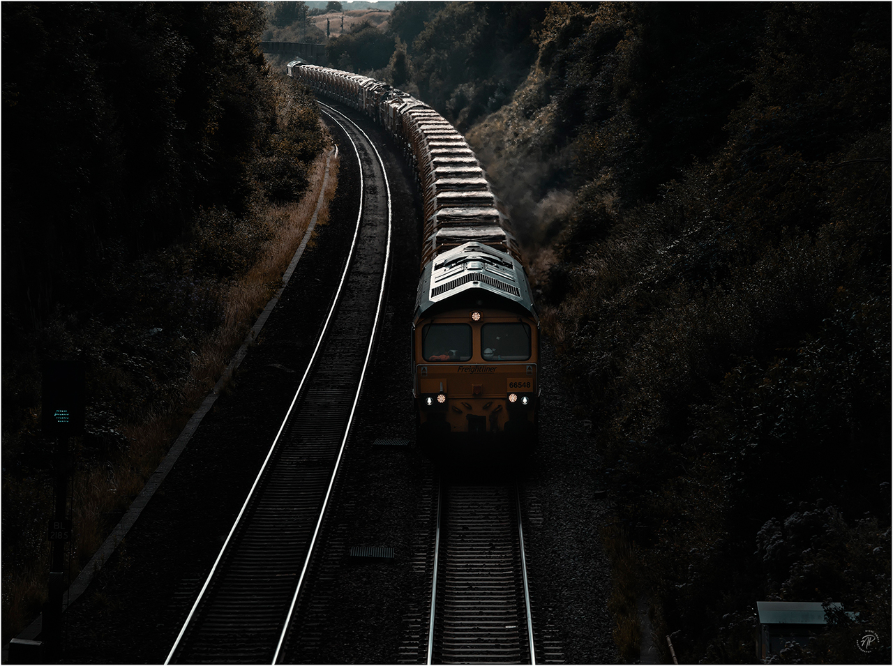 Down in the Cutting
At 1843hrs on Tuesday 25 July 2023, an engineering train passes up the line at Flax Bourton in North Somerset. Freightliner locos 66548 (front) and 66568 provided the traction for a lengthy rake of loaded HOBC wagons. This train was 6X37, the Fairwater Yard (1750hrs) to Tilehurst East Junction working. Some heavy, dark clouds sat above this scene, but backlight cut in at the rear of the train.
