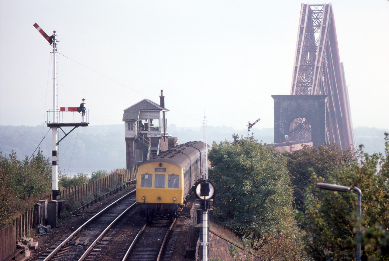 A view from North Queensferry
The magnificent Forth Bridge features quite often in these galleries, almost all images taken showing its grandeur from down by the water. In a contrast, this view from North Queensferry station is of a DMU arriving from Edinburgh showing the Bridge, signal box and semaphore signals on a hazy day.
Keywords: Forth Bridge;North Queensferry