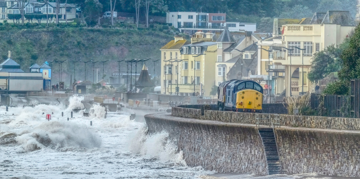 There is a Storm Coming.
66003 is towing 37703 as the 0Z09 0826 Westbury to Paignton. The 37 had arrived at Westbury the previous day from Harry Needles Worksop facility.
The rough seas were a prelude to the storm which arrived the following day.
37703 will be restored at the Paignton and Dartmouth Railway.
As seen in issue 331 of Rail Express.
