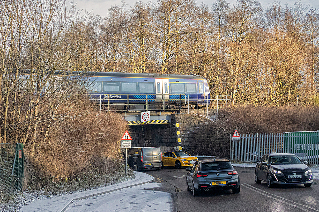 To Aberdeen from Inverness
A notorious bottle neck on a rat run in Inverness. Behind where the picture was taken is a level crossing with an uneven road surface. When the gates close the traffic backs up to and blocks a roundabout on the main route into the 'city'. The bridge creates a narrow defile at an angle to the road where there is no provision for a pedestrian walkway.

