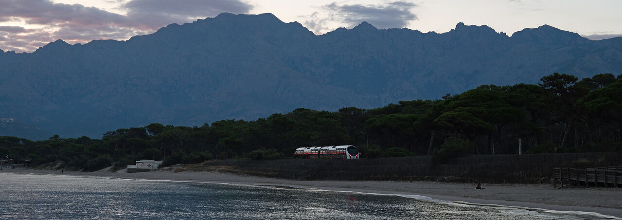 First train of the day
Corsican metre-gauge: The morning train to Bastia leaves Calvi at 0705, just about right for sunrise in September. The line runs along the back of Calvi beach for about a mile, catching a reflection from the sky (if you're lucky) as it curves around the last section at the north end of the beach.
